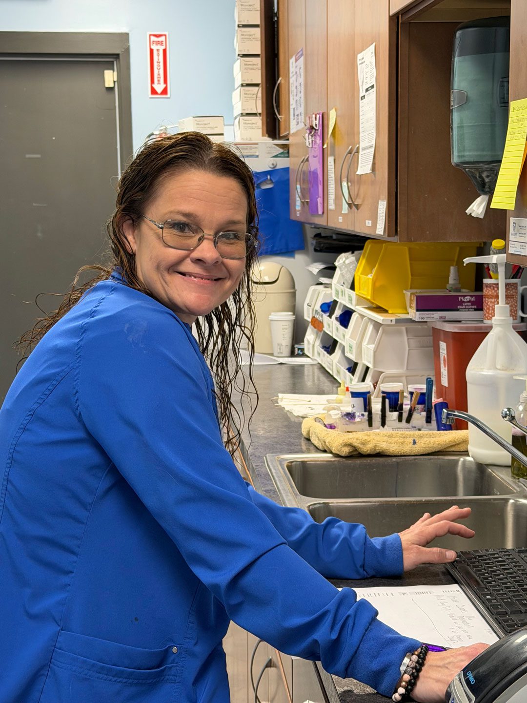 smiling female veterinary staff member using the computer